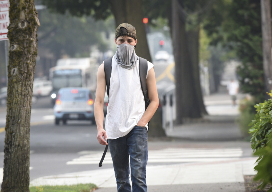 Alexander Fuller of Vancouver walks down Main Street in Vancouver on Tuesday wearing a face mask to protect himself from smoke and ash in the air caused by the Eagle Creek Fire in the Columbia River Gorge.