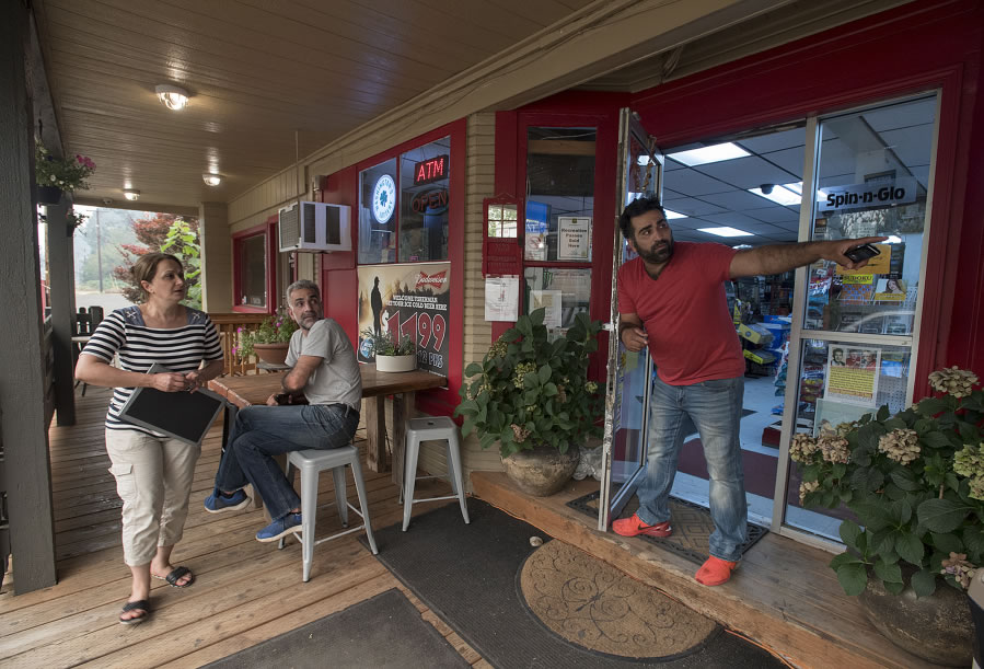 Rose Zamani, from left, Reza Imani and Amir Imani of Skamania General Store continue to help customers while uncertain about the future because of the wildfire burning nearby. Businesses in the Gorge face logistical challenges with road closures and evacuations.