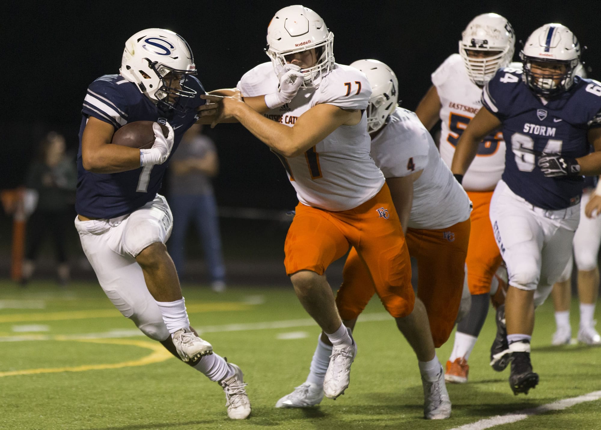 Storm Angelo Sarchi (1) fends off Crusader Ryan Taylor (77) during the Friday night football ball game at Kiggins Bowl between Skyview High School and Eastside Catholic School on Sept. 8, 2017.