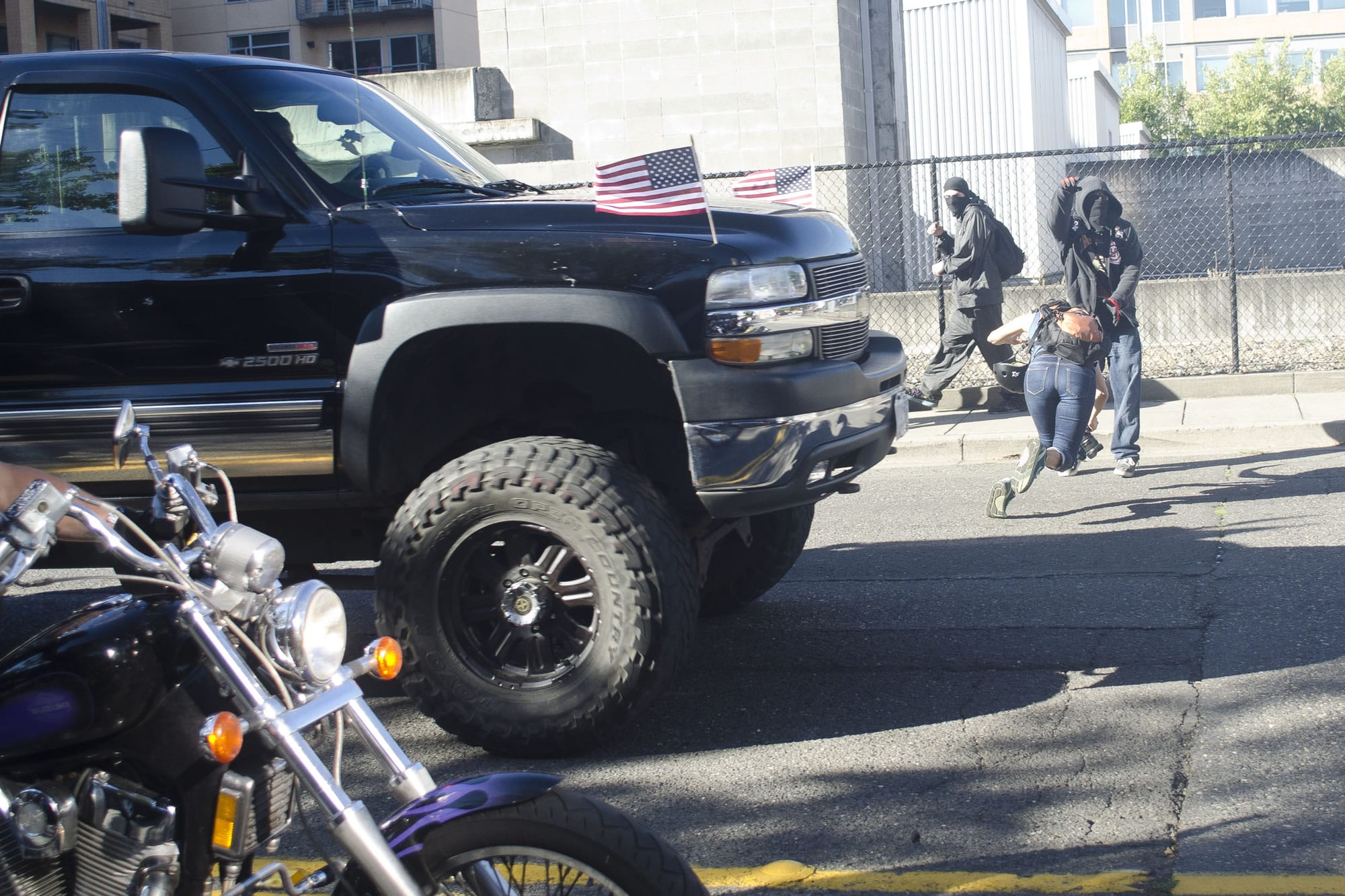A photographer dives out of the way of a truck after a rally held by Joey Gibson's Patriot Prayer Group in Vancouver on Sunday. The event was moved to Vancouver from Portland in an attempt to avoid protesters.