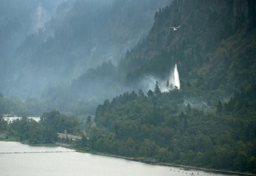 A helicopter makes a water drop on the Eagle Creek Fire on Thursday in this view from the Cape Horn overlook along Highway 14. Improved conditions also allowed water drops on the Archer Mountain Fire in western Skamania County.