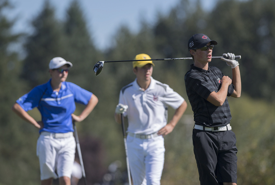 Graham Moody of Mountain View, from left, and Keith Lobis of Union look on as Camas’ Owen Huntington tees off on the 12th hole during the Jeff Hudson Invitational High School Golf Tournament at Tri-Mountain Golf Course on Tuesday morning, Sept. 12, 2017.