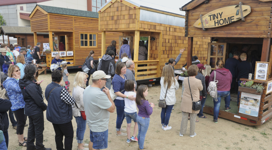 Long lines of visitors wait to tour the different tiny houses at the Tiny House Living Festival at the Clark County Event Center at the Fairgrounds on Saturday. The festival, bringing 17 tiny houses on wheels, eight converted school buses and other minimalist living options, ends Sunday.