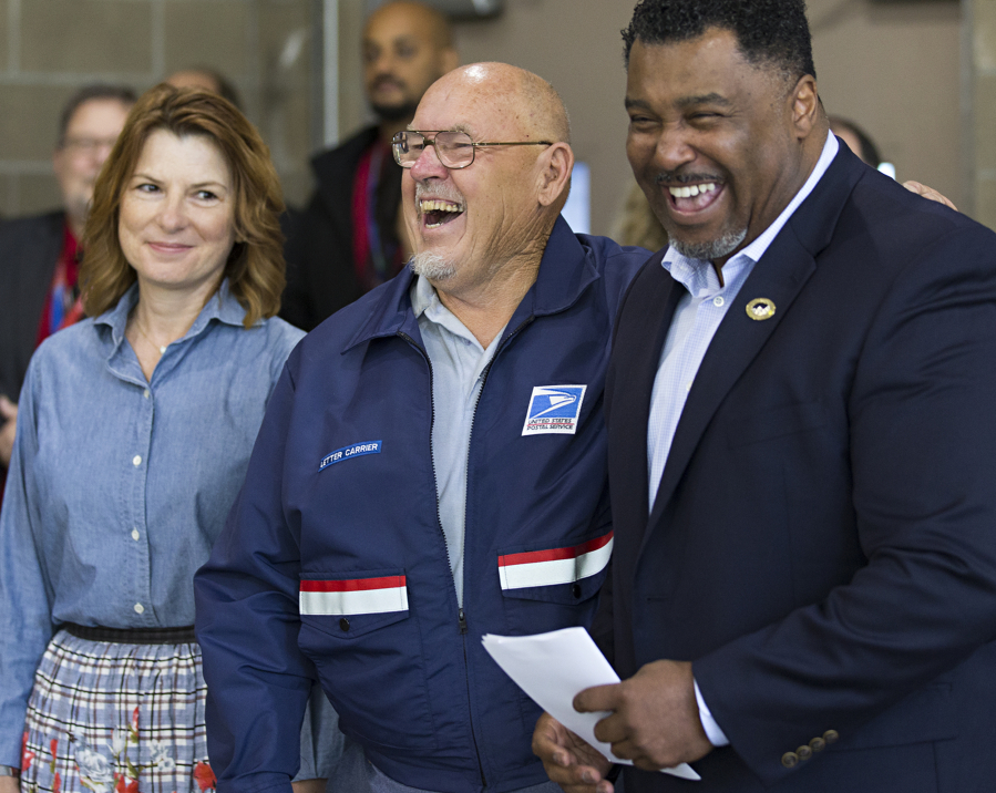Postmaster of Ridgefield Carmen Arthur, left, Cody Hershaw, center, and Tyrone Williams, district manager of the East Vancouver Post Office, laugh during a ceremony honoring Hershaw for being named safest postal driver in the Western Area.