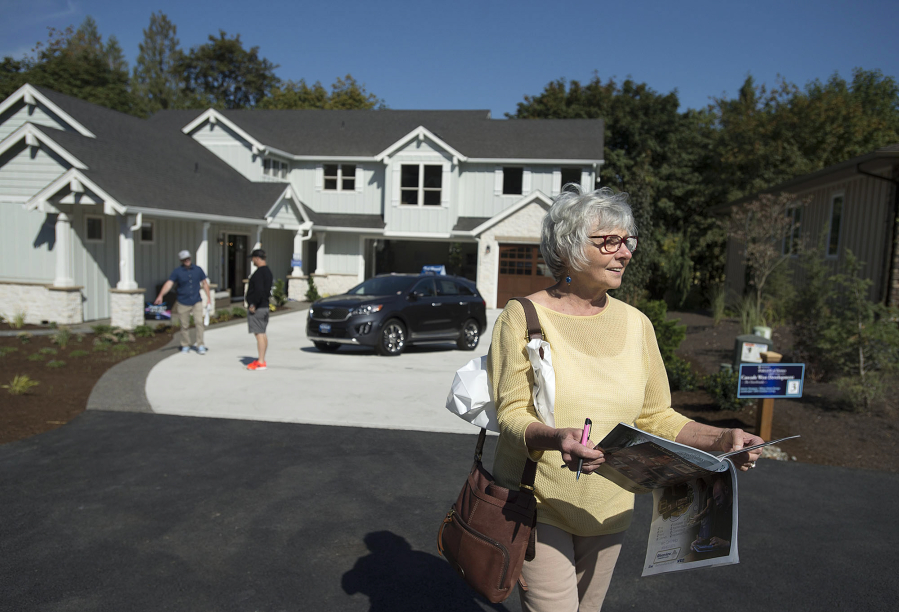 Bev Lopatka of Battle Ground pauses outside The Overbrooke, a four-bedroom home, while looking over an informational booklet during the Parade of Homes.