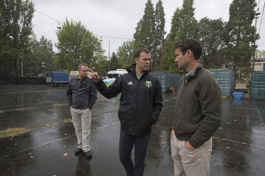 Greg McGreevey of Pacific FC, from left, joins Jack Jewsbury of the Portland Timbers and Bart Hansen of the Vancouver City Council as they tour a possible site Monday afternoon for a new futsal court near the Fort Vancouver Regional Library district headquarters.