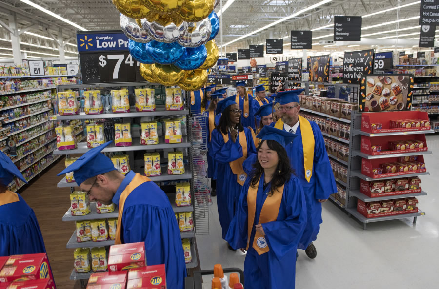 Wal-Mart workers parade the Marrion neighborhood store in Vancouver after graduating Wal-Mart Academy. Regional manager Troy Cuff said training programs like the academy help retain employees and lift its customer service, which is needed as e-commerce grows.