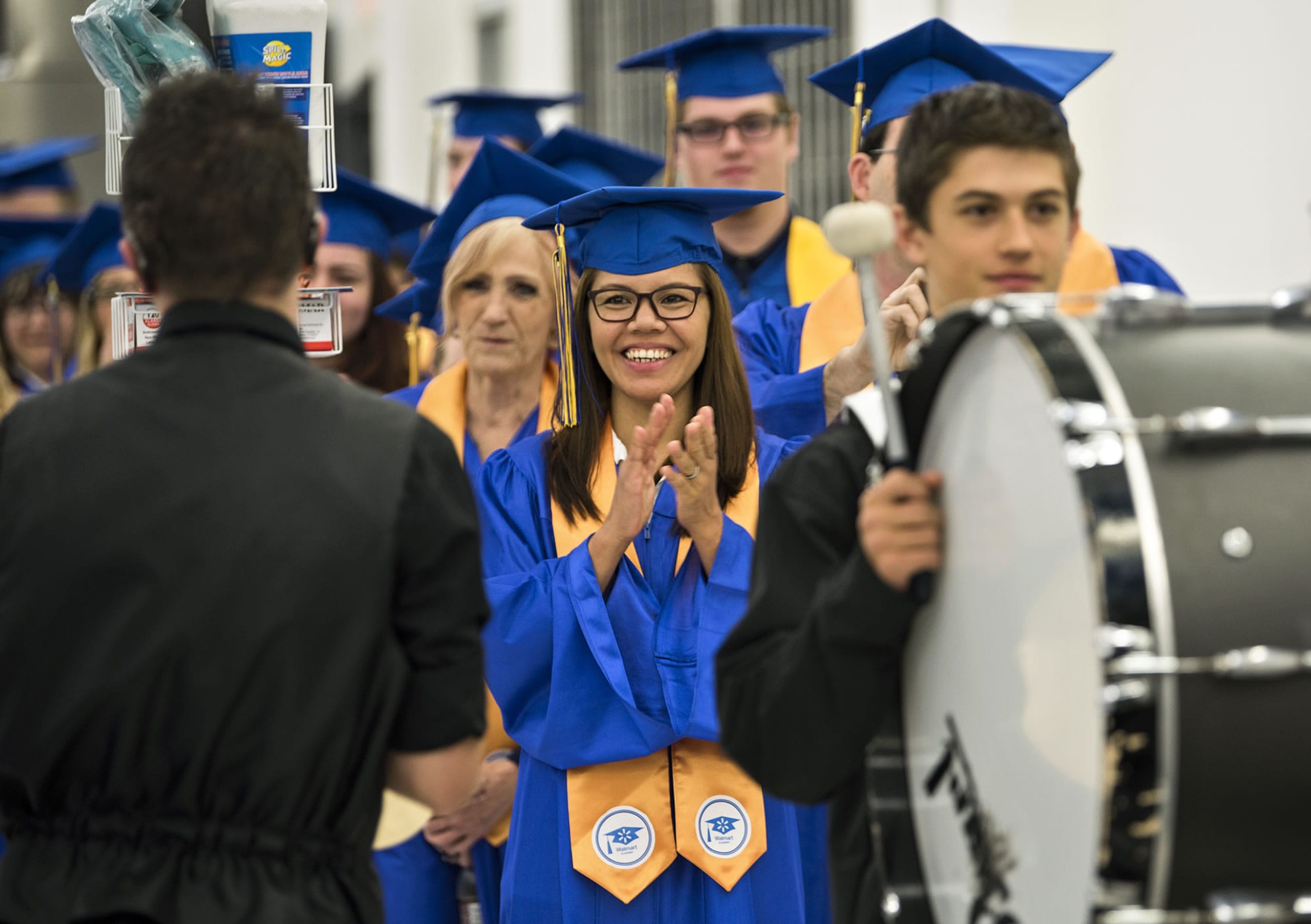 Agnes Abero of Vancouver cheers on the Prairie High School marching band before the first Walmart Academy graduation at the Vancouver Walmart Supercenter on Tuesday morning, Sept. 26, 2017. Members of the marching band paraded the graduates throughout the store at the beginning of the ceremony.