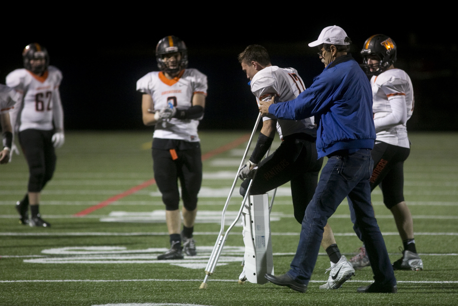 Washougal’s Brevan Bea heads off the field on crutches after suffering fractures to his left tibia and fibula during the Panthers’ win over Ridgefifeld on Friday.