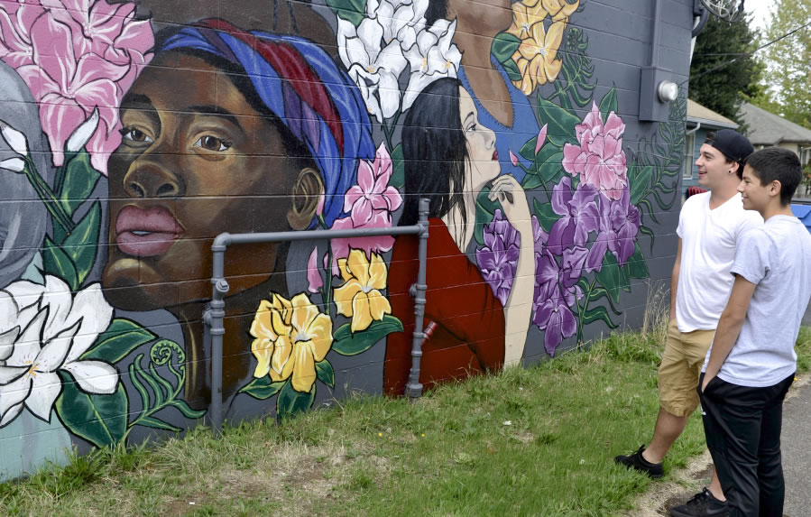 Garrett Holiday, left, and Isaiah Romero check out one of four recently finished murals painted on the walls of buildings along East Fourth Plain Boulevard. The murals were created as part of the Fourth Plain Forward effort.