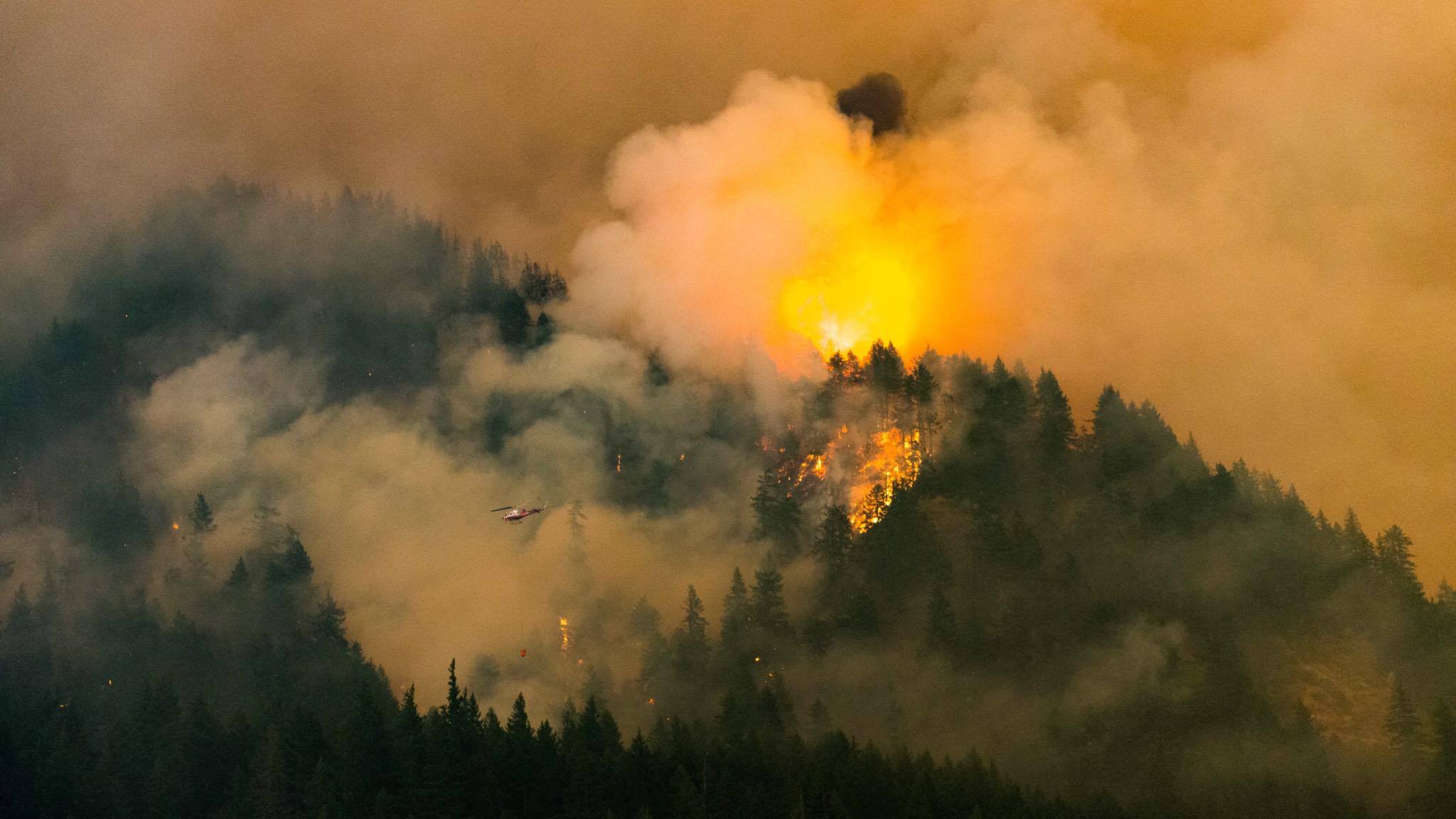 A helicopter fights the Eagle Creek Fire in Oregon on Monday as seen from the Bonneville Dam area Monday night.