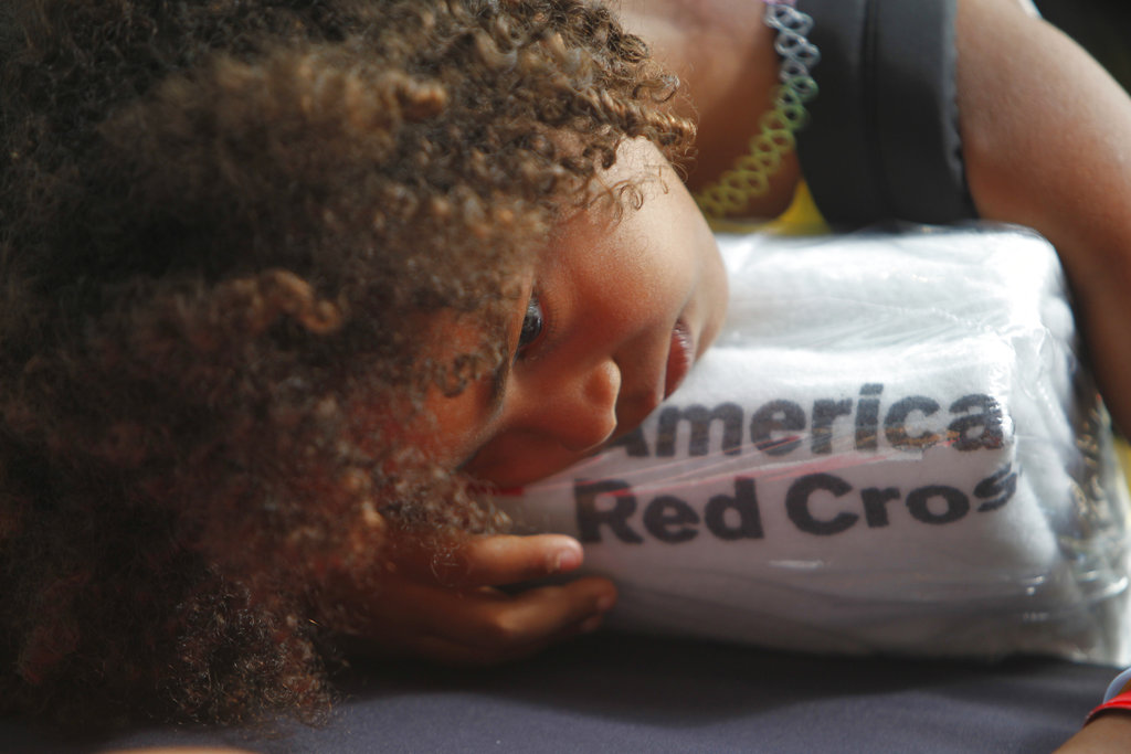 A girl rests her head on a set of towels supplied by the American Red Cross after arriving in San Juan, Puerto Rico, Thursday, Sept. 14, 2017, on a cruise ship with families evacuated from Caribbean islands devastated by Hurricane Irma. Many of those arriving in Puerto Rico live in the U.S. and British Virgin Islands and were heading toward the U.S. mainland to leave their children with relatives and then go back home to resume work and rebuild their lives.