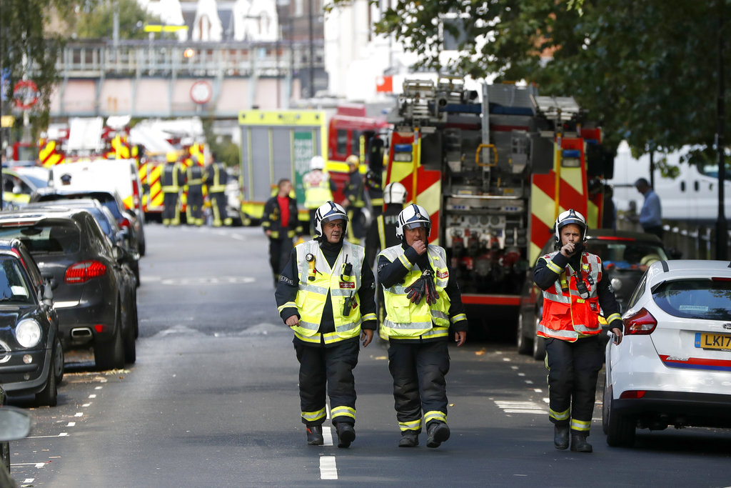 Fire brigade officers walk within a cordon near where an incident happened, that police say they are investigating as a terrorist attack, at Parsons Green subway station in London, Friday, Sept. 15, 2017. A bucket wrapped in an insulated bag caught fire on a packed London subway train Friday, sending commuters stampeding in panic at the height of the morning rush hour.