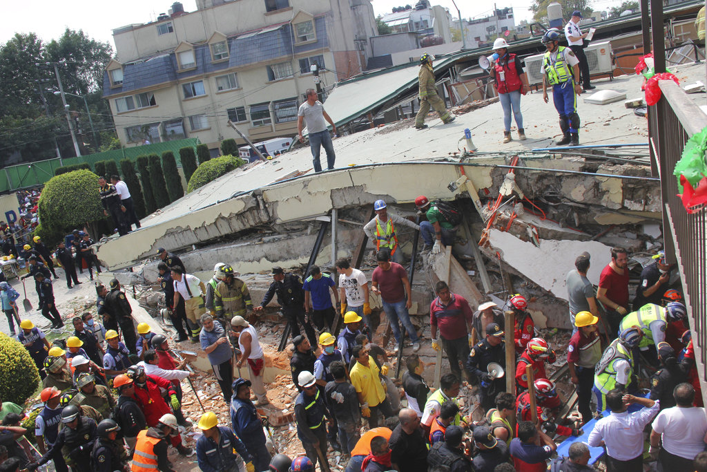 Rescue workers search for children trapped inside the collapsed Enrique Rebsamen school in Mexico City, Tuesday, Sept. 19, 2017. The earthquake stunned central Mexico, killing more than 100 people as buildings collapsed in plumes of dust.