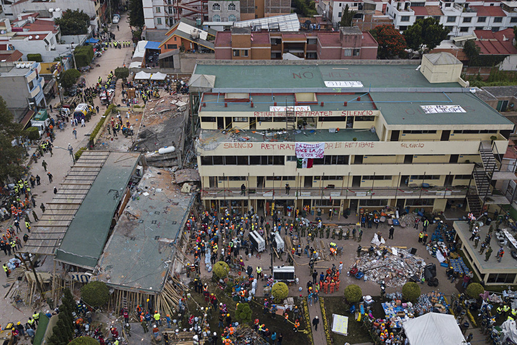 Volunteers and rescue workers search for children trapped inside the Enrique Rebsamen school, collapsed by a 7.1 earthquake in southern Mexico City, Wednesday Sept. 20, 2017. One of the most desperate rescue efforts was at the school, where a wing of the three-story building collapsed into a massive pancake of concrete slabs. The school's rooftops and facade bore messages that called for silence and for no helicopters to flyover, so as not to drown out the sounds of anyone who may trapped in the rubble.