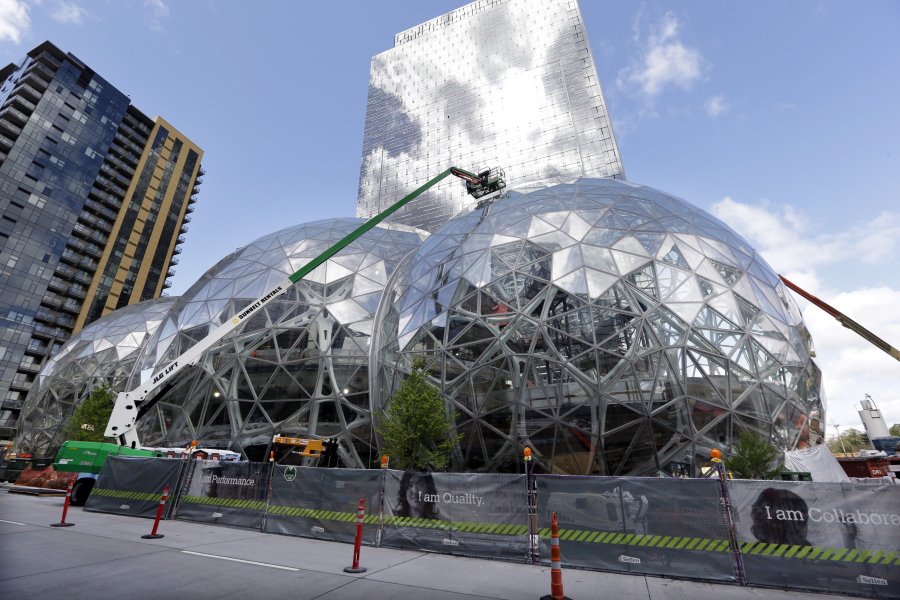 Construction continues on three large, glass-covered domes as part of an expansion of the Amazon.com campus in downtown Seattle. Amazon said Thursday that it will spend more than $5 billion to build another headquarters in North America to house as many as 50,000 employees. It plans to stay in its sprawling Seattle headquarters and the new space will be “a full equal” of its current home, said founder and CEO Jeff Bezos.