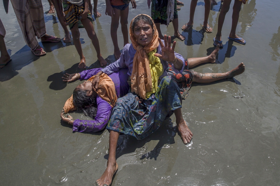 A Rohingya Muslim woman, who crossed over from Myanmar into Bangladesh, shouts for help as a relative lies unconscious after the boat they were traveling in capsized minutes before reaching shore at Shah Porir Dwip, Bangladesh, on Thursday. Nearly three weeks into a mass exodus of Rohingya fleeing violence in Myanmar, thousands were still flooding across the border Thursday in search of help and safety in teeming refugee settlements in Bangladesh.