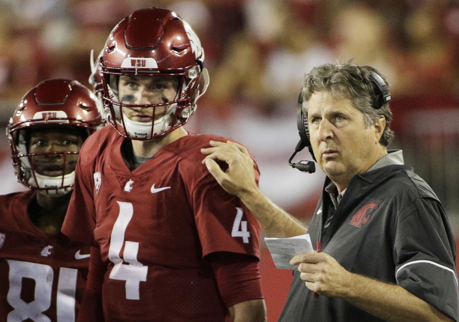 Washington State coach Mike Leach, right, speaks with quarterback Luke Falk during the first half of an NCAA college football game against Boise State in Pullman, Wash., Saturday, Sept. 9, 2017.