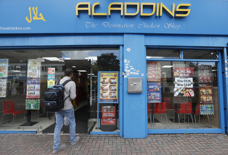 A man walks into Aladdins, a fast food restaurant in Hounslow, London, on Monday. The two suspects detained over last week’s London subway bombing are an 18-year-old refugee from Iraq and a 21-year old believed to be from Syria, both of whom were fostered by a British couple, according to a local official and media reports. The 18-year-old was detained Saturday at the southeast England port of Dover, a departure point for ferries to France. The 21-year-old was held later the same day in Hounslow in west London.