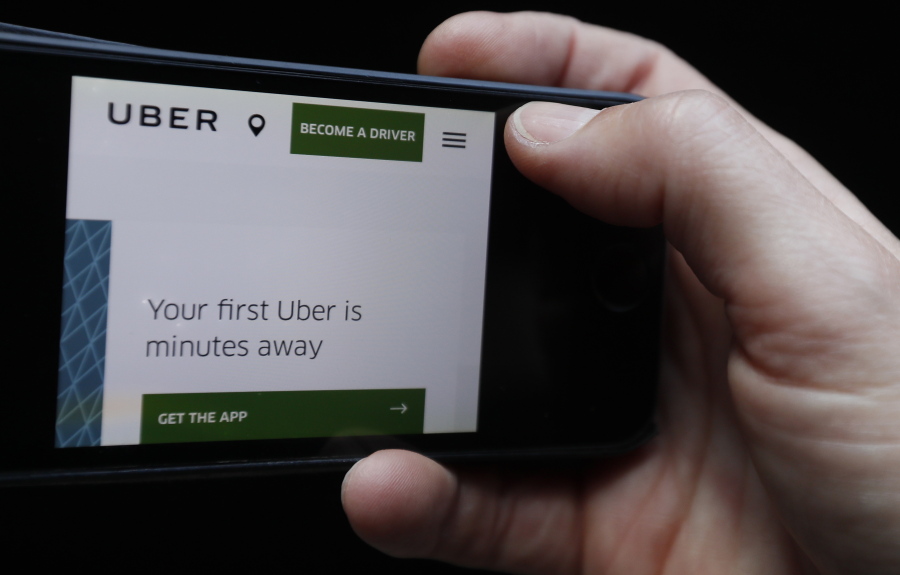 The Uber website is displayed on a phone in London, Friday. London’s transport authority said Friday it won’t renew Uber’s license to operate in the British capital, arguing that it demonstrates a lack of corporate responsibility with implications in public safety and security.