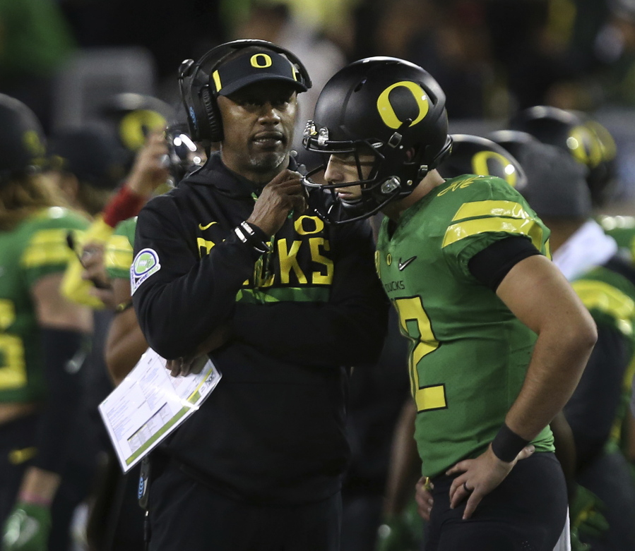 Oregon head coach Willie Taggart, left, talks to backup quarterback Taylor Allie after starting quarterback Justin Herbert left the field with an apparent injury during the first quarter against California in an NCAA college football game Saturday, Sept. 30, 2017, in Eugene, Ore.