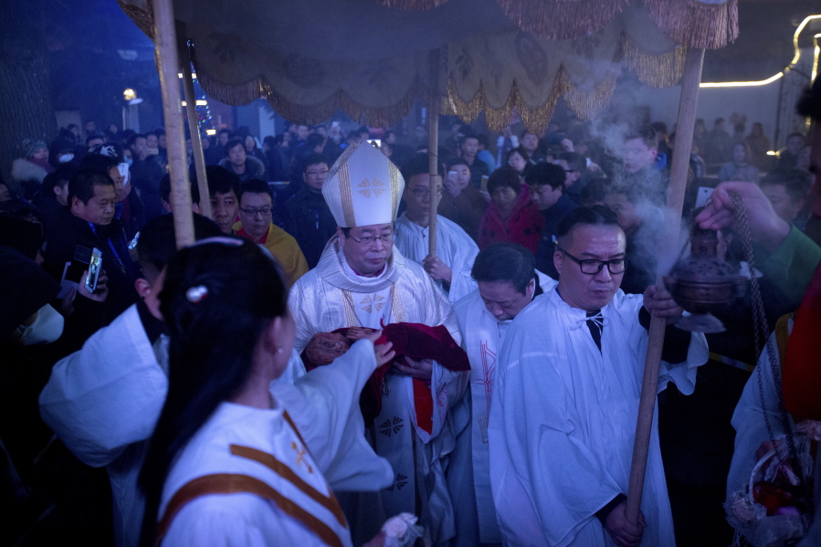 Chinese bishop Joseph Li Shan, center, arrives Dec. 24, 2015, for a Christmas Eve mass at the Southern Cathedral, an officially sanctioned Catholic church in Beijing. The Vatican’s efforts to heal a decades-long rift with China appear to have stalled, with each side still unwilling to accept controversial bishops appointed by the other. In recent months, Beijing has appeared to take a harder line toward believers, and has ordered the country’s estimated 12 million Catholics to shun foreign influence and to “Sinosize” their Church.