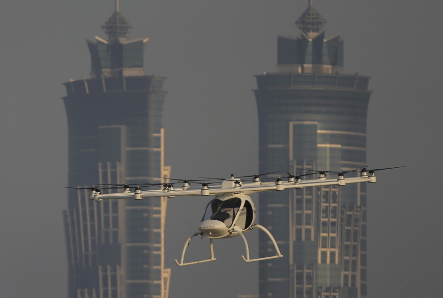 In this Sept. 26, 2017 photo, a Volocopter prototype flies in front of the two hotel towers during a test flight in Dubai, United Arab Emirates. Dubai is hoping to one day have flying, pilotless taxis darting among its skyscrapers. Just this week, the city-state in the United Arab Emirates hosted crews from the German company Volocopter, which had an electric, battery-powered two-seat prototype take off and land. Dubai hopes to have rules in place in the next five years to be ready for having the aircraft regularly flying through its skies.