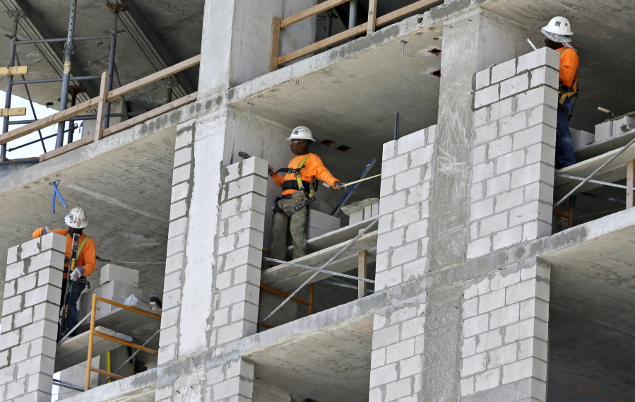 Construction workers work on an apartment high rise in May in Miami. On Thursday, the Commerce Department issues the third and final estimate of how the U.S. economy performed in the April-June quarter.