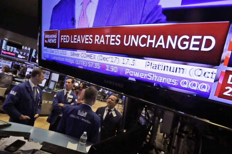 The rate decision of the Federal Reserve appears on a television screen, on the floor of the New York Stack Exchange on Wednesday. The Federal Reserve says it will start in October to gradually unwind its $4.5 trillion balance sheet, which expanded to unprecedented levels in efforts to spur economic growth after the 2008 financial crisis.