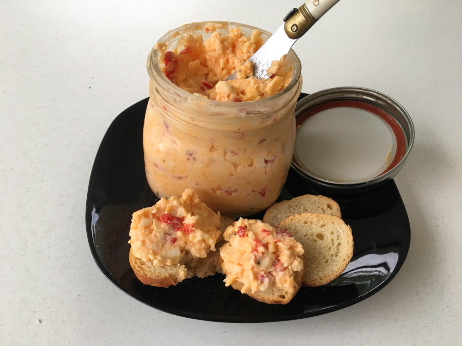 Classic Pimento Cheese from a recipe by Elizabeth Karmel, in Houston, Texas. This comfort food is basically only three simple ingredients, sharp cheddar cheese, jarred pimentos and mayonnaise - but when you combine them, you get a creamy, sharp, piquant spread that is so versatile you can use it for just about any meal part.