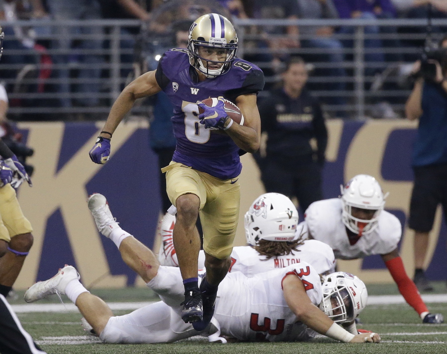 Washington’s Dante Pettis (8) leaves several Fresno State defenders in his wake on his punt return for a touchdown in the first half of an NCAA college football game Saturday, Sept. 16, 2017, in Seattle. Pettis tied the NCAA career record for punt return touchdowns on the 77-yard return, the eighth of his career.