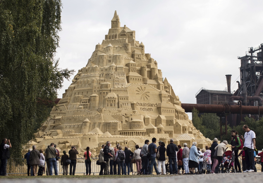 Visitors surround a sandcastle at the Landschaftspark in Duisburg, Germany, on Friday. Artists attempt to secure a spot in the coveted Guinness Book of World Records by building the tallest sandcastle ever.