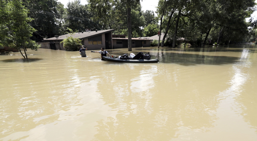 Gaston Kirby, right, and Juan Minutella leave Kirby’s flooded home in the aftermath of Hurricane Harvey, Monday, Sept. 4, 2017, near the Addicks and Barker Reservoirs, in Houston. (AP Photo/David J.