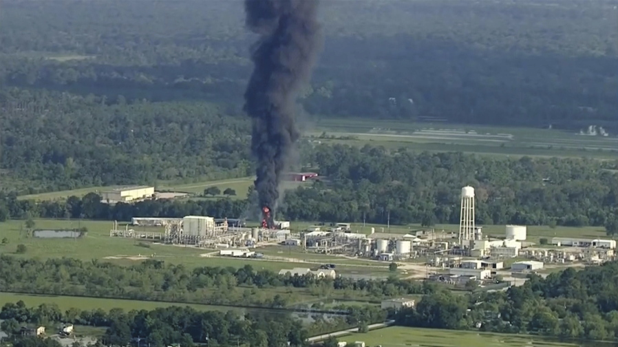 Black smoke and towering orange flames shoot up Friday from a flooded Houston-area chemical plant.