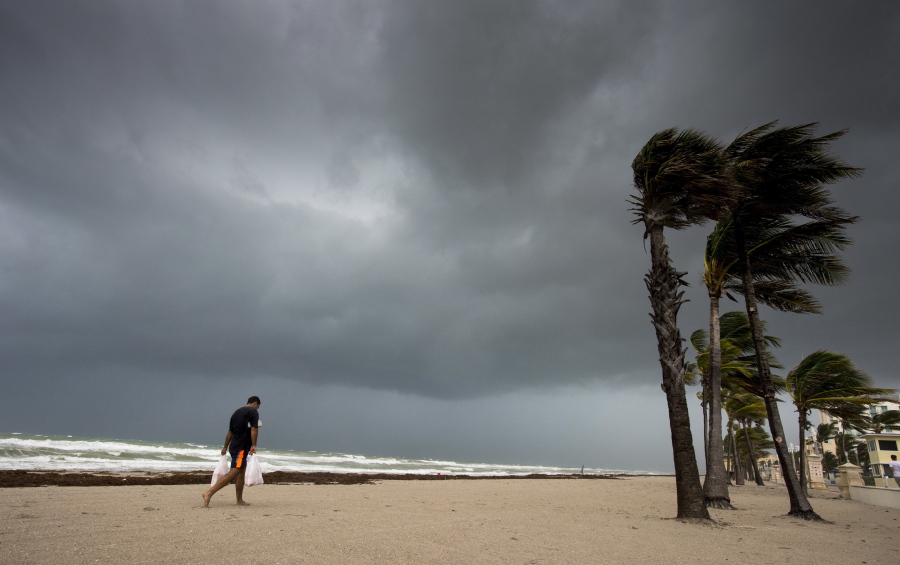A man walks along the beach with heavy winds and threatening skies in Hollywood, Fla., as Hurricane Irma approaches the state on Saturday.