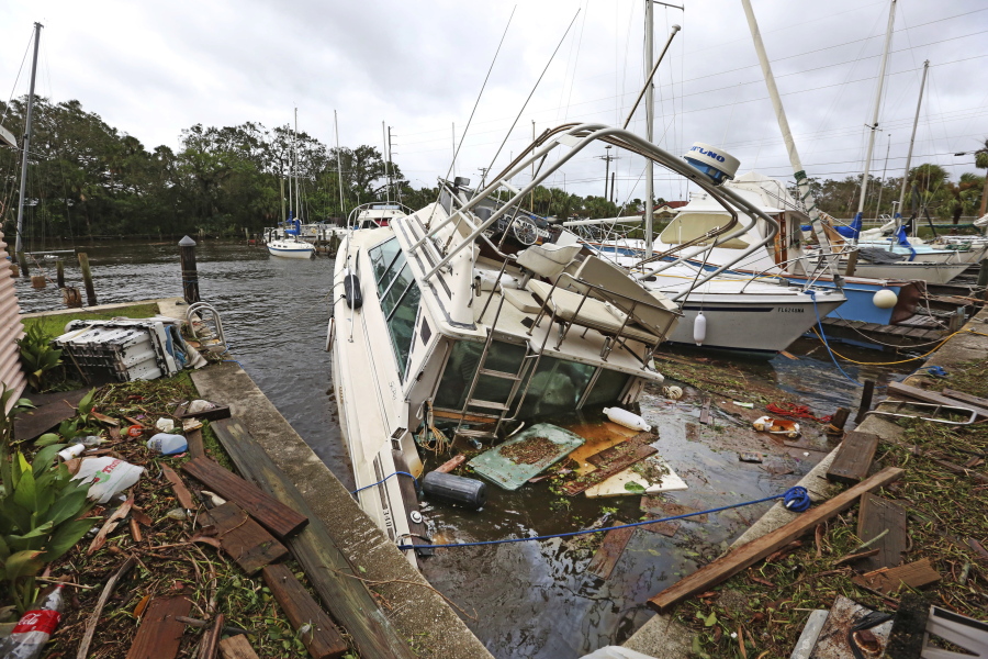 A sinking boat is surrounded by debris Monday in the aftermath of Hurricane Irma in Palm Shores, Fla.