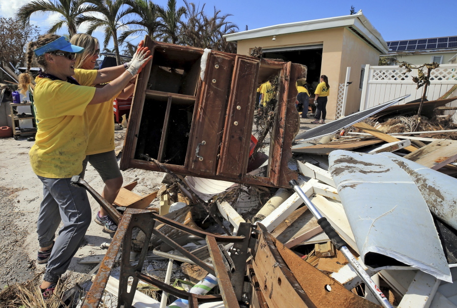 Maria Stotts, and Heather Mueller, volunteers from the Church of Jesus Christ of Latter-Day Saints, clear debris from a Monroe County sheriff’s deputy’s home damaged by a six-foot storm surge Sunday in Big Pine Key, Fla.