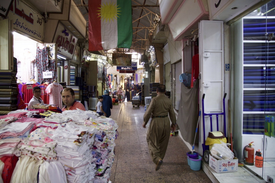 A Kurdish man wearing traditional clothes passes under a Kurdish flag in Irbil’s old bazaar, Iraq. Despite calls from Baghdad and the United States to postpone the vote, Iraq’s semi-autonomous Kurdish region is pressing ahead with plans to hold a referendum on independence September 25.