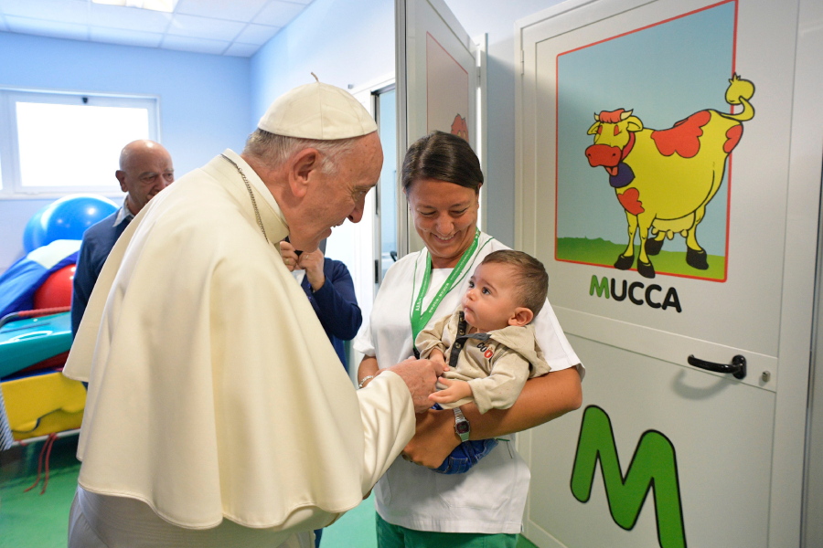 Pope Francis talks to an infant during his visit to the Santa Lucia Foundation in Rome, Friday, Sept. 22, 2017.