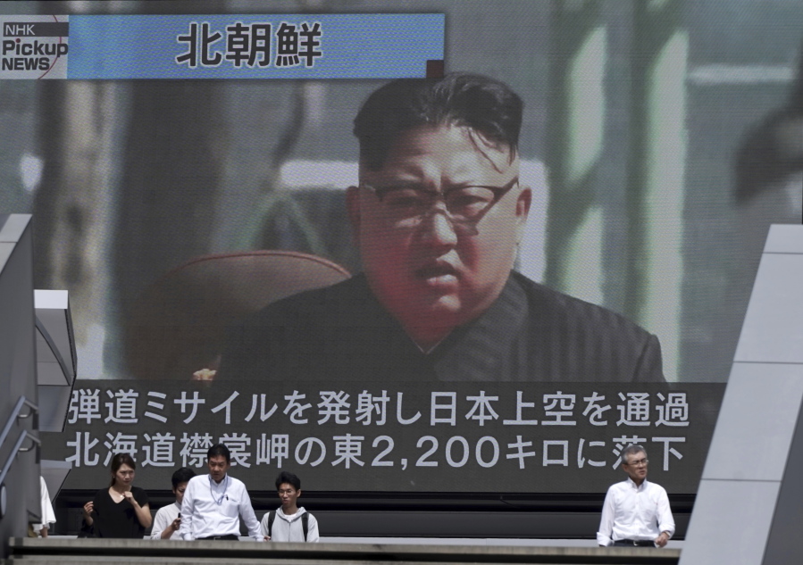 People walk past a public TV screen showing a file footage of North Korean leader Kim Jong Un during news on North’s missile launch, in Tokyo, on Friday. North Korea fired an intermediate-range missile over Japan into the northern Pacific Ocean on Friday, U.S. and South Korean militaries said, its longest-ever such flight and a clear message of defiance to its rivals.