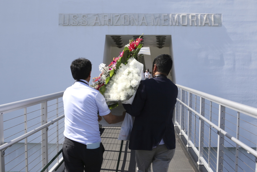 Members of Nippon Izokukai, the Bereaved Family Association of Japan, carry flowers onto the USS Arizona Memorial in Pearl Harbor, Hawaii, Thursday, Sept. 21, 2017. Dozens of descendants of Japanese soldiers killed in World War II visited Pearl Harbor on Thursday to pay respects to American war dead. Nippon Izokukai sent about 36 children, grandchildren and other relatives of fallen Japanese soldiers to the U.S. to mark the 70th anniversary of the group’s founding. With the rusted hull of the USS Arizona beneath them, the group laid flowers and a wreath at the memorial after touring the Pacific Aviation Museum and the USS Missouri at Pearl Harbor.