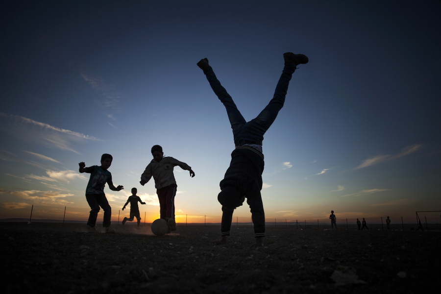 A coach’s assistant does a handstand while Syrian children play soccer at the Zaatari refugee camp near the Syrian border in Jordan. Aleksander Ceferin, the head of European soccer’s governing body and Jordan’s Prince Ali have inaugurated a full-size soccer pitch in Jordan’s largest camp for Syrian refugees. Organizers say the pitch is meant to give a sense of normalcy to 80,000 residents of Zaatari, which was set up in 2012, a year after the start of the Syria crisis.