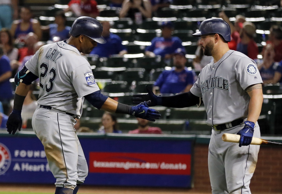 Seattle Mariners' Nelson Cruz (23) is congratulated by Yonder Alonso after Cruz hit a solo home run off Texas Rangers relief pitcher A.J. Griffin during the seventh inning of a baseball game, Thursday, Sept. 14, 2017, in Arlington, Texas.