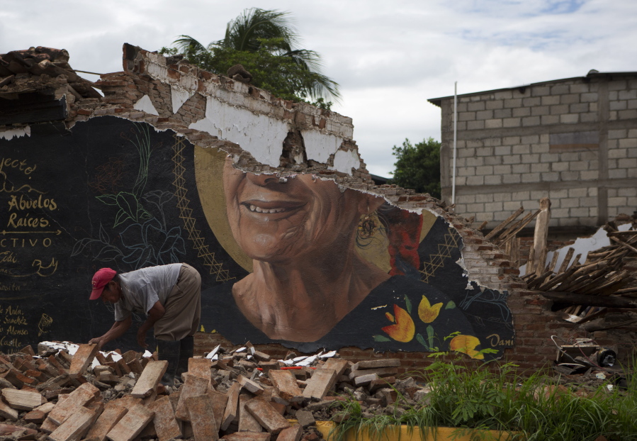 A man recovers bricks from a building destroyed in Thursday’s magnitude 8.1 earthquake, in Union Hidalgo, Oaxaca state, Mexico, on Sunday. Mexico’s government is distributing food to jittery survivors of an earthquake while residents have continued to sleep outside, fearful of more collapses and aftershocks.