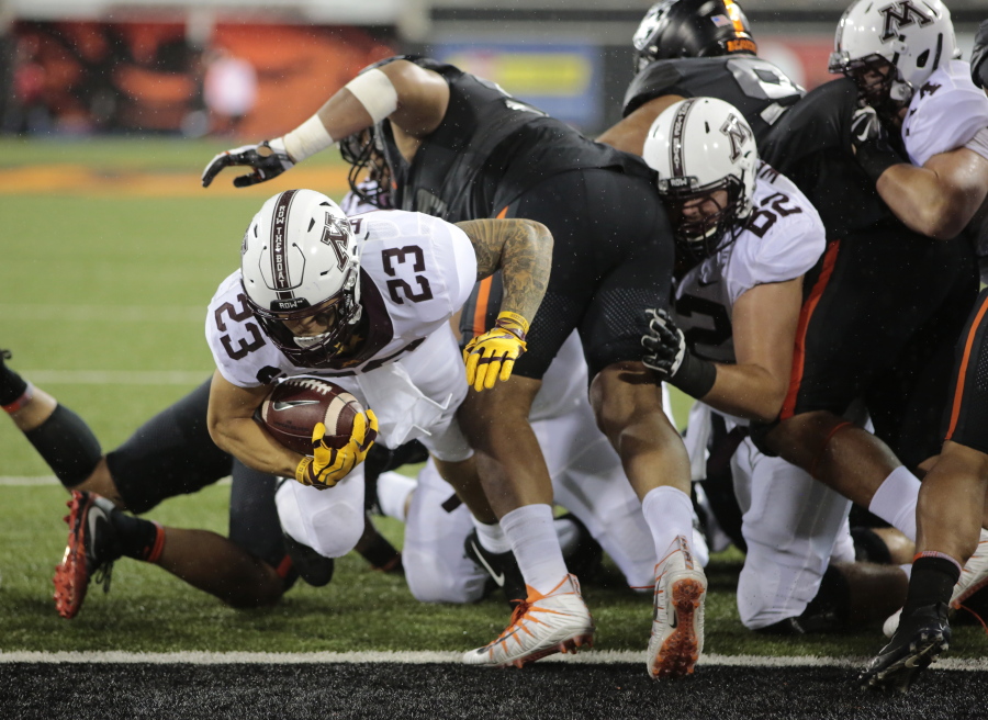 Minnesota’s Shannon Brooks (23) fights his way through the Oregon State defensive line for a touchdown during the first half of an NCAA college football game in Corvallis, Ore., Saturday, Sept. 9, 2017. (AP Photo/Timothy J.
