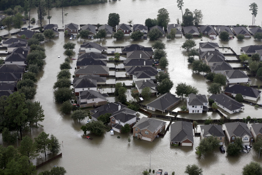 FILE - In this Tuesday, Aug. 29, 2017, file photo, Homes are surrounded by floodwaters from Tropical Storm Harvey in Spring, Texas. Doing an inventory of all of your possessions while your home is safe and sound makes it easier to file an insurance claim after a disaster such as Hurricane Harvey. (AP Photo/David J.