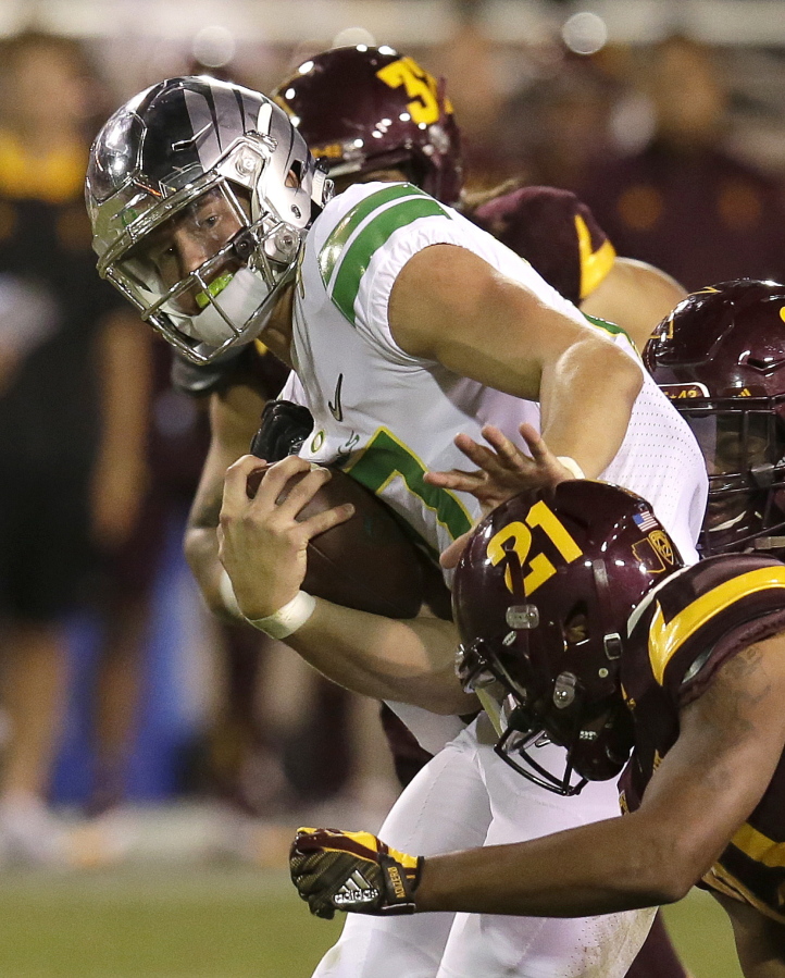 Oregon quarterback Justin Herbert (10) pushes off from Arizona State defensive back Chad Adams during the second half of an NCAA college football game, Saturday, Sept. 23, 2017, in Tempe, Ariz.