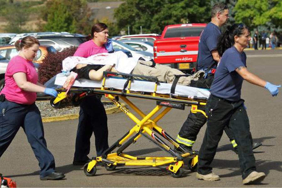 FILE - In this Oct. 1, 2015, file photo, authorities move a shooting victim away from the scene after a gunman opened fire at Umpqua Community College in Roseburg, Ore. Oregon authorities have released a detailed report on the 2015 shooting that left nine people dead and nine injured. The report released Friday, Sept. 8, 2017, includes a six-page, typewritten ‘manifesto’ that the suspect, Christopher Harper-Mercer, left on a thumb drive for police to find.