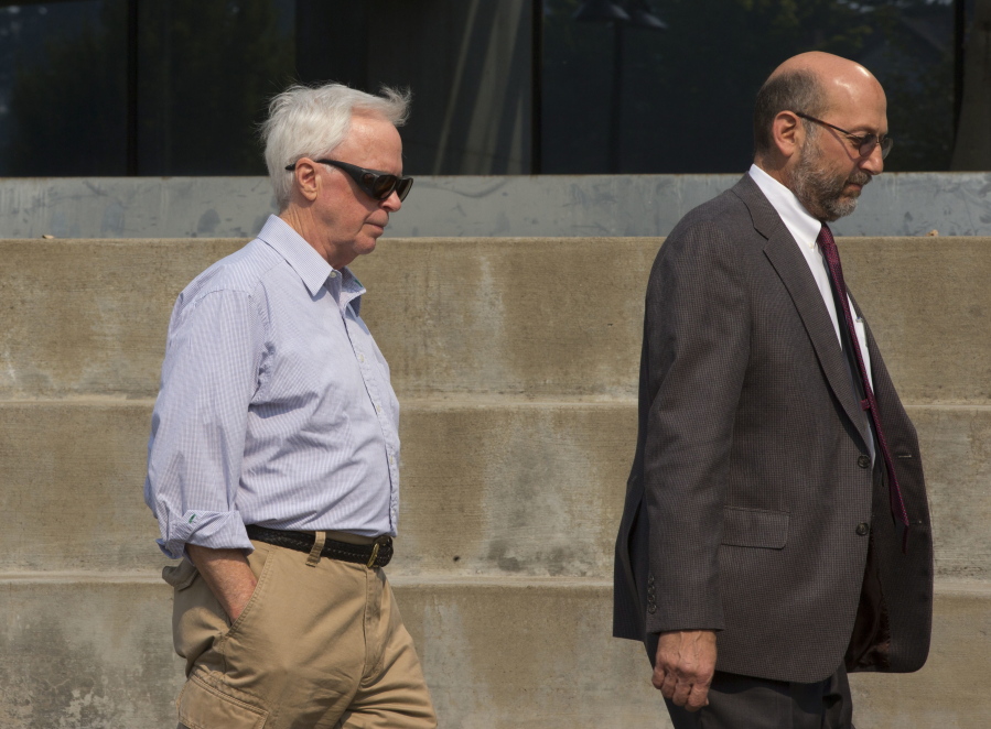 Gary Holcomb, left, leaves the Wayne L. Morse U.S. Courthouse in Eugene, Ore., Friday after he, his brother, Michael Holcomb, as well as his nieces Jennifer Chalmers and Kristen Van Beemen pleaded guilty in court as part of the Berjac investment firm Ponzi scheme case.