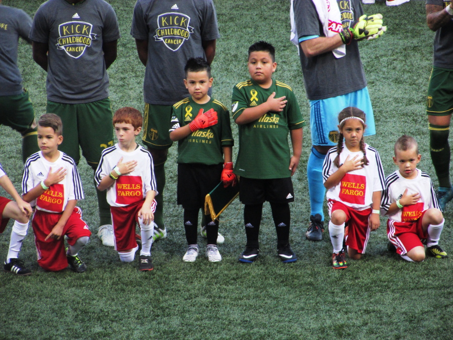 Five-year-old Derrick Tellez and his older brother Josue Tellez, right, take part in the national anthem on field with the Portland Timbers before a soccer match against Orlando City on Sunday, Sept. 24, 2017, in Portland, Ore. Derrick Tellez, a goalkeeper, was signed to a one-game contract with the Timbers as part of his wish with Make-A-Wish Oregon. (AP Photo/Anne M.
